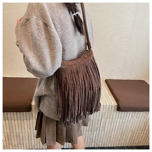 Détail du sac bandoulière en daim marron avec longues franges rétro et fine bandoulière