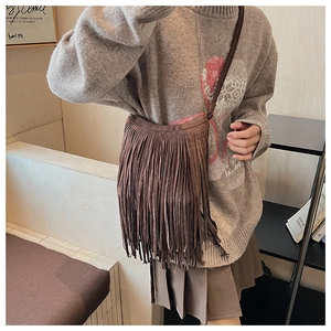 Détail du sac bandoulière bohème en daim marron foncé avec de longues franges