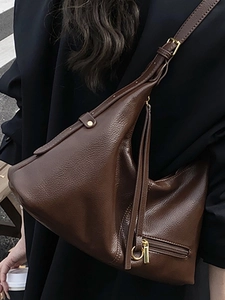 Deep brown lychee texture leather tote bag with gold metal zipper shown in a crossbody style