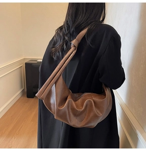 Detail of coffee brown slouchy dumpling bag with unique knot detail on the shoulder strap