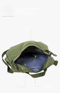 Detail view of army green checkered shoulder bag featuring multiple storage compartments