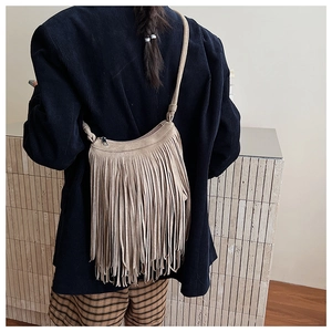 Vue détaillée du sac bandoulière kaki avec de longues franges et une texture en suède