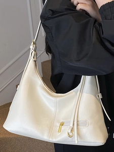 Cream-colored large tote bag in soft pebble leather finish with gold hardware accents