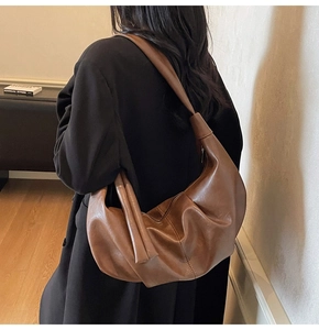 Detail of caramel brown oversized leather hobo bag with vertical stitching craftsmanship