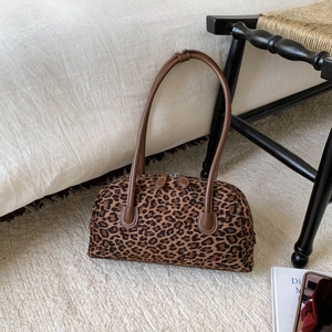 Détail du sac Boston à motif léopard avec poignées en similicuir marron sur un tapis