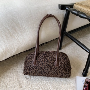 Détail du sac Boston à imprimé léopard avec anses en cuir marron et fermeture éclair en métal