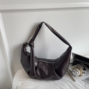 Detail view of large dark brown leather hobo bag with soft pleated design and knotted strap