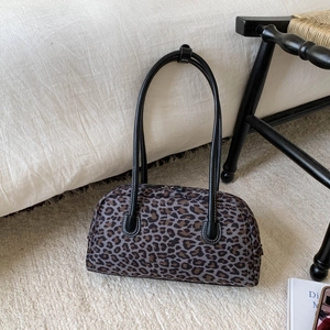 Détail de la texture léopard et de l'anse en cuir noir du sac Boston de style vintage