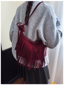Detailed view of the layered dark red suede fringes on a retro crossbody shoulder bag