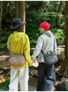 Detail of grey and khaki checkered outdoor crossbody bags with adjustable straps