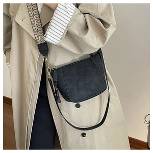 Detail of black matte shell bag showing dual straps and vintage geometric patterns
