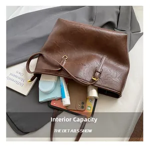 Detail showing internal capacity of the brown tote bag with tablets and books inside