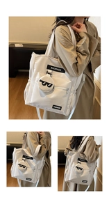 Détail du sac de tutorat en toile avec porte-monnaie rond et patch lunettes sur sangle