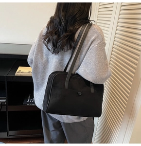 Minimalist black rectangular suede shoulder bag styled on a model in a modern room