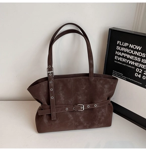 Detail view of large dark brown tote bag with vintage texture and adjustable belt buckle