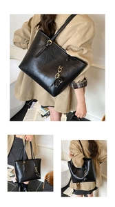 Detail of vintage texture black tote bag showing gold buckle and brand logo on leather