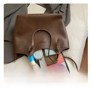 Spacious dark brown tote bag interior holding a tablet, phone, and cosmetics for work