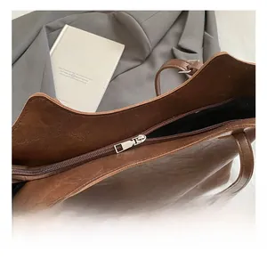 Close-up of high-quality metal zipper and textured leather on a brown tote bag