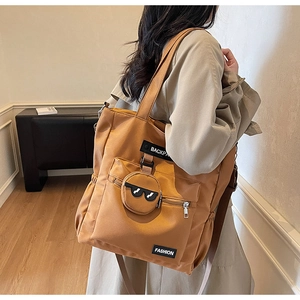 Détail du grand cabas en nylon marron avec poches multiples et petit sac rond décoratif