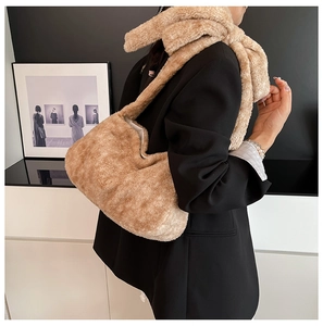 Detailed texture of khaki faux fur bucket bag styled with a professional black blazer jacket