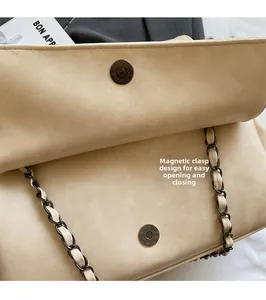 Detail of beige suede chain bag with magnetic clasp for easy opening and closing