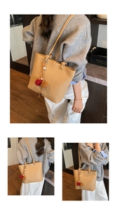 Detailed woven straw tote bag texture with leather straps and decorative plush pom-poms