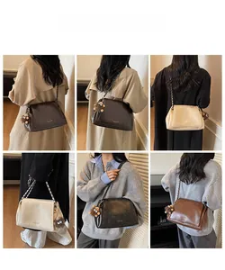 Detail showing high-capacity leather tote bag in brown, beige, and black with plush charm