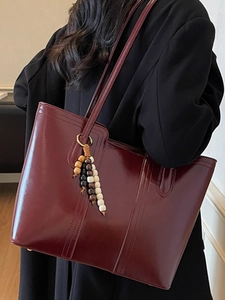 Large burgundy patent leather tote bag with stylish beaded charm for commute
