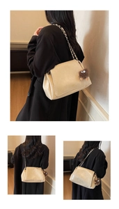 Detail of off-white faux leather shoulder bag with chain strap and cute plush charm