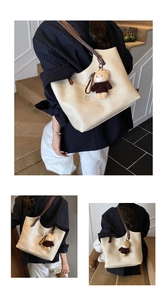Detail view of large beige tote bag with leather straps and cute bear charm accent
