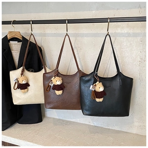 Detailed view of fashionable tote bags in three colors with teddy bear charms