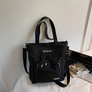 Détail du sac cabas noir à poches multiples avec porte-monnaie rond et étiquettes