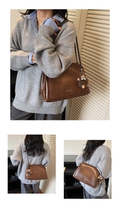 Close-up of brown vintage leather tote with woven metal chain strap and plush monkey charm