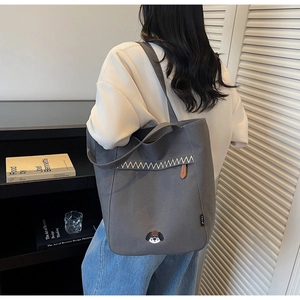 Détail du sac cabas en toile grise avec broderie chiot et surpiqûres décoratives