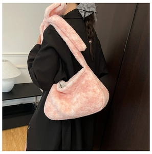 Pink plush hobo bucket bag shown on shoulder over black coat for winter style