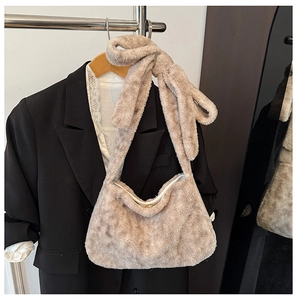 Close-up of fluffy faux fur bucket bag in beige showing soft plush texture and wide strap