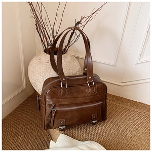 Macro detail of brown vintage tote bag with zipper pocket and metal buckle strap