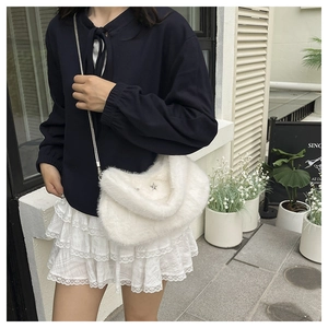 Détail du sac croissant en peluche blanche avec boucle étoile argentée et chaîne
