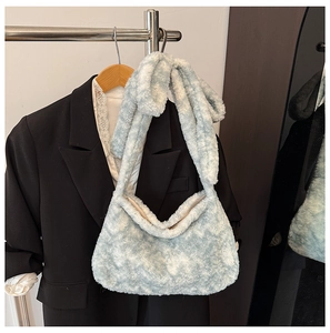 Detail showing plush faux fur texture of the light blue bucket bag with soft cloud finish