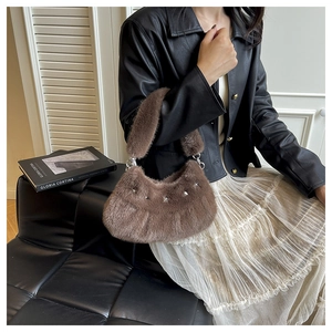 Gros plan du sac en peluche marron avec des rivets métalliques en étoile et texture douce
