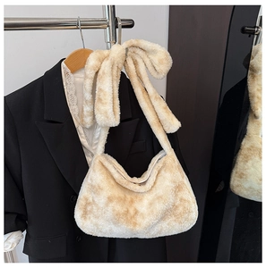 Detail of plush bucket bag featuring a large faux fur bow on the shoulder strap