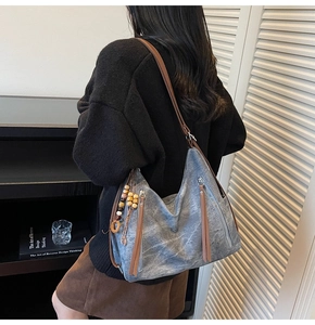 Detail of washed canvas tote bag featuring brown leather straps and vintage tassels