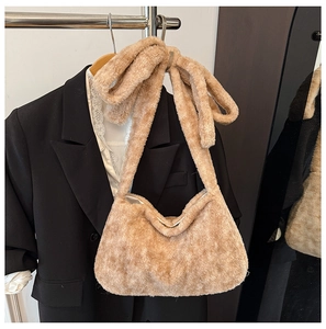 Detail of plush bucket bag with oversized bow strap and soft faux fur texture