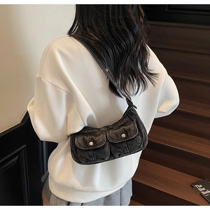 Detailed back view of vintage black washed denim crescent bag with metallic buttons