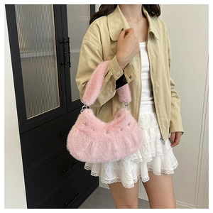 Détail d'un sac en peluche rose avec rivets étoiles argentées et texture douce en fausse fourrure