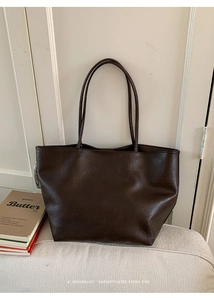 Detailed texture of dark brown faux leather tote bag with a minimalist retro vibe