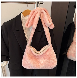 Detail of pink plush bucket bag with a stylish bow shoulder strap and soft faux fur texture