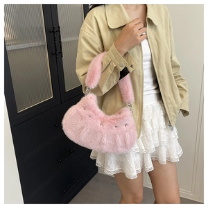 Gros plan du sac selle en fausse fourrure rose avec étoile argentée et texture douce