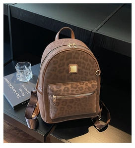 Detail of leopard print backpack featuring suede texture and gold metallic hardware