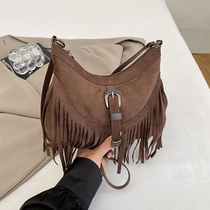 Detail of brown suede crescent bag with long fringe tassels and vintage buckle
